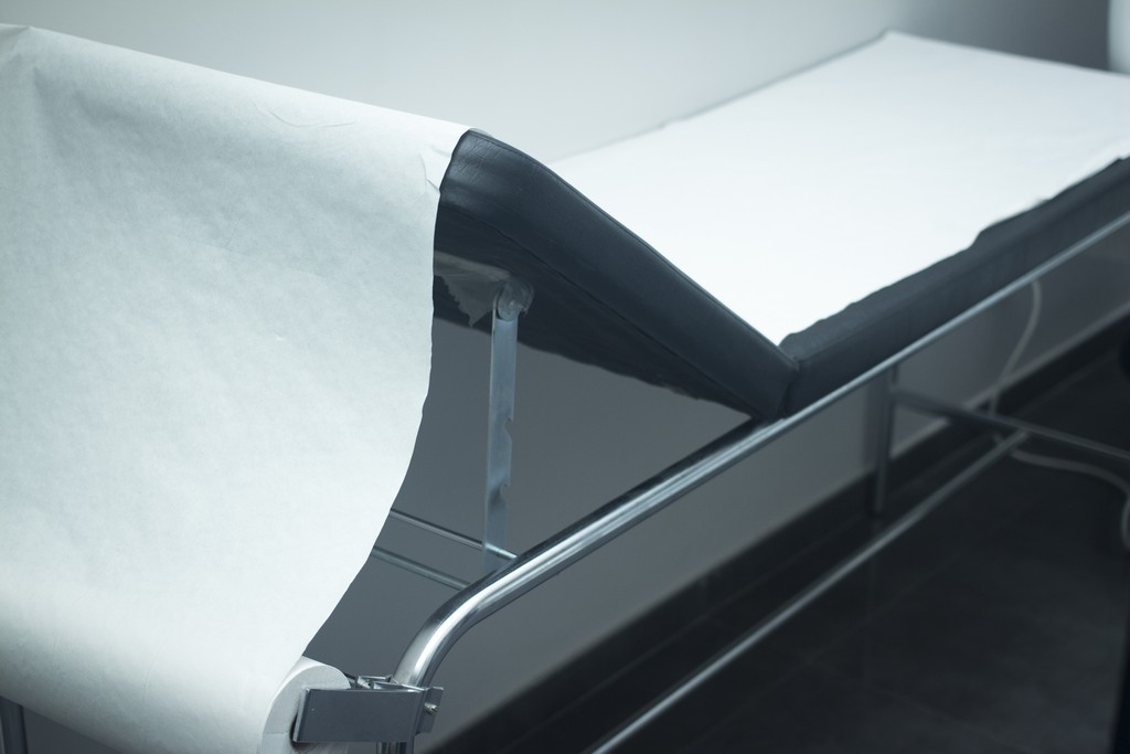 Physiotherapy hospital clinic patient bed and paper roll covering photo.
